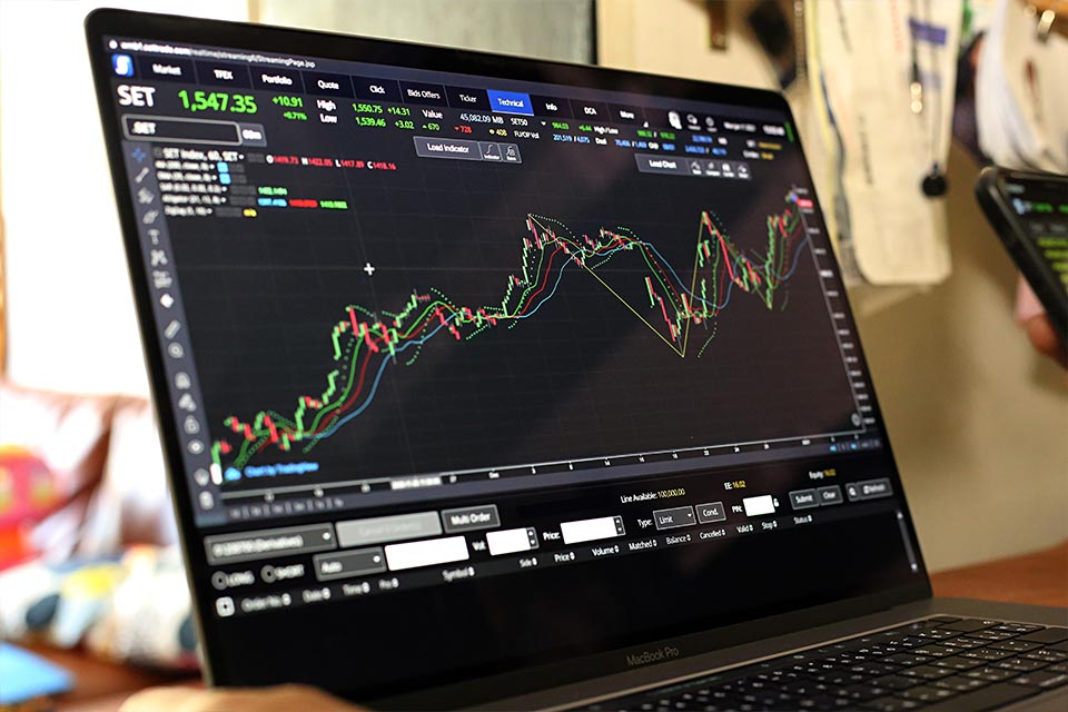 Trading platform displayed on a laptop screen, featuring technical indicators, illustrating top momentum indicators to analyze trend strength.
