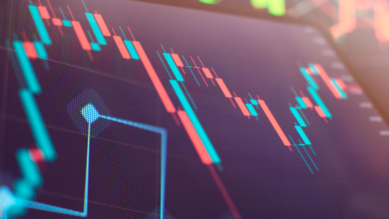 Hedging vs Speculation: Top Differences – A digital trading chart displaying candlestick patterns in red and blue, symbolizing market fluctuations and contrasting strategies in risk management and profit-seeking.