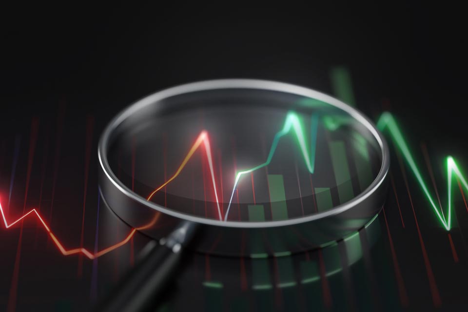 A magnifying glass highlighting forex trading signals on a digital chart, representing the search for the best forex trading signals.