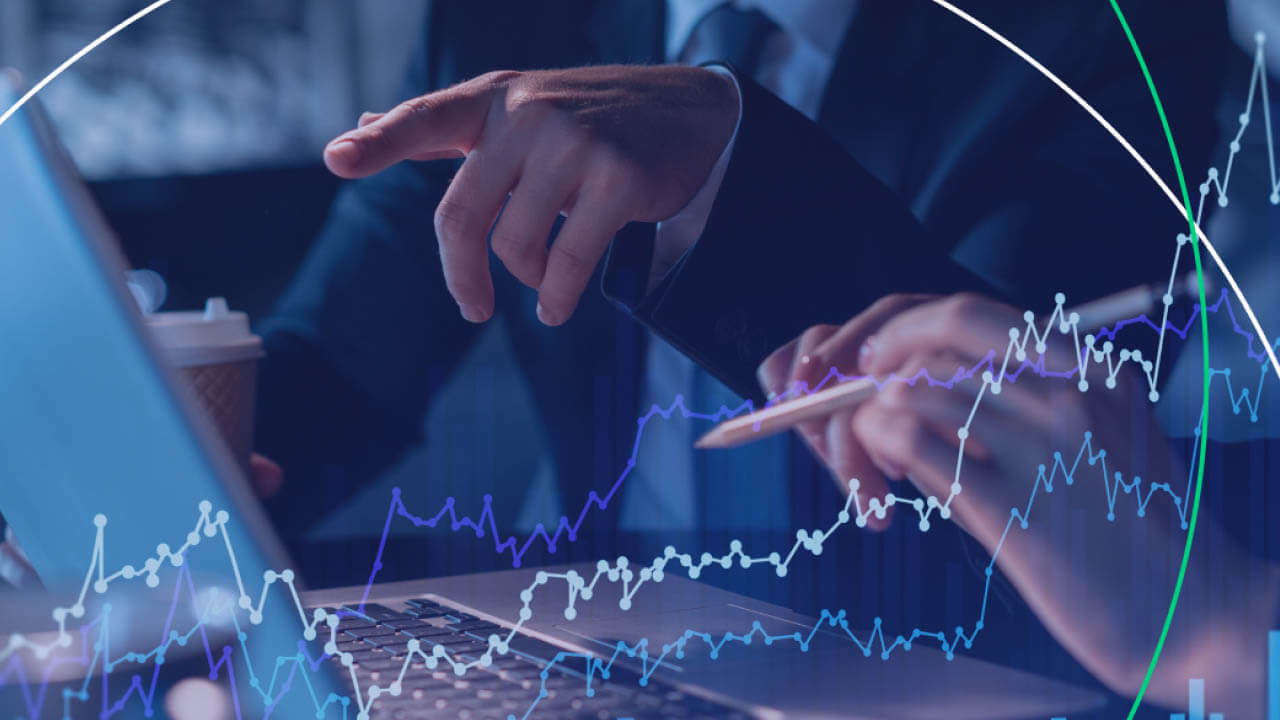 Two professionals analyzing financial data on a laptop, illustrating the concept of Carry Trade in Forex.