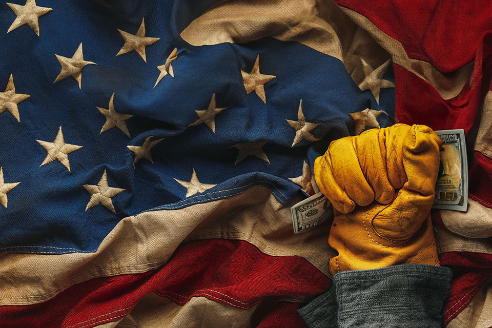 A worn American flag with deep folds and faded colors, illustrating dollar retreats ahead of US jobs report looms