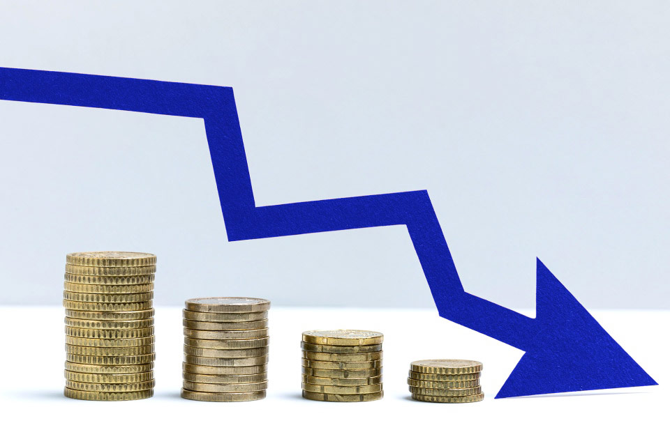 Stacked coins decreasing in height with a downward blue arrow, illustrating why you should set (and stick to) a maximum trading loss.