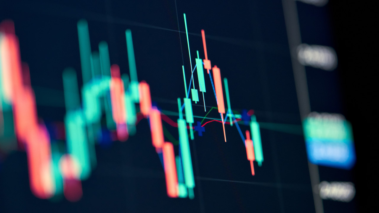 A close-up view of a candlestick chart showing price movements and triangle chart patterns, used in technical analysis for trading decisions.