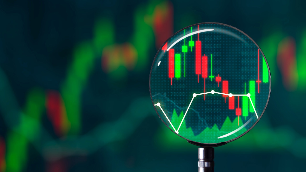 What is the Hidden Divergence Trading Strategy? A magnifying glass highlighting candlestick patterns and trend lines on a financial chart, representing market analysis and hidden divergence signals in trading.