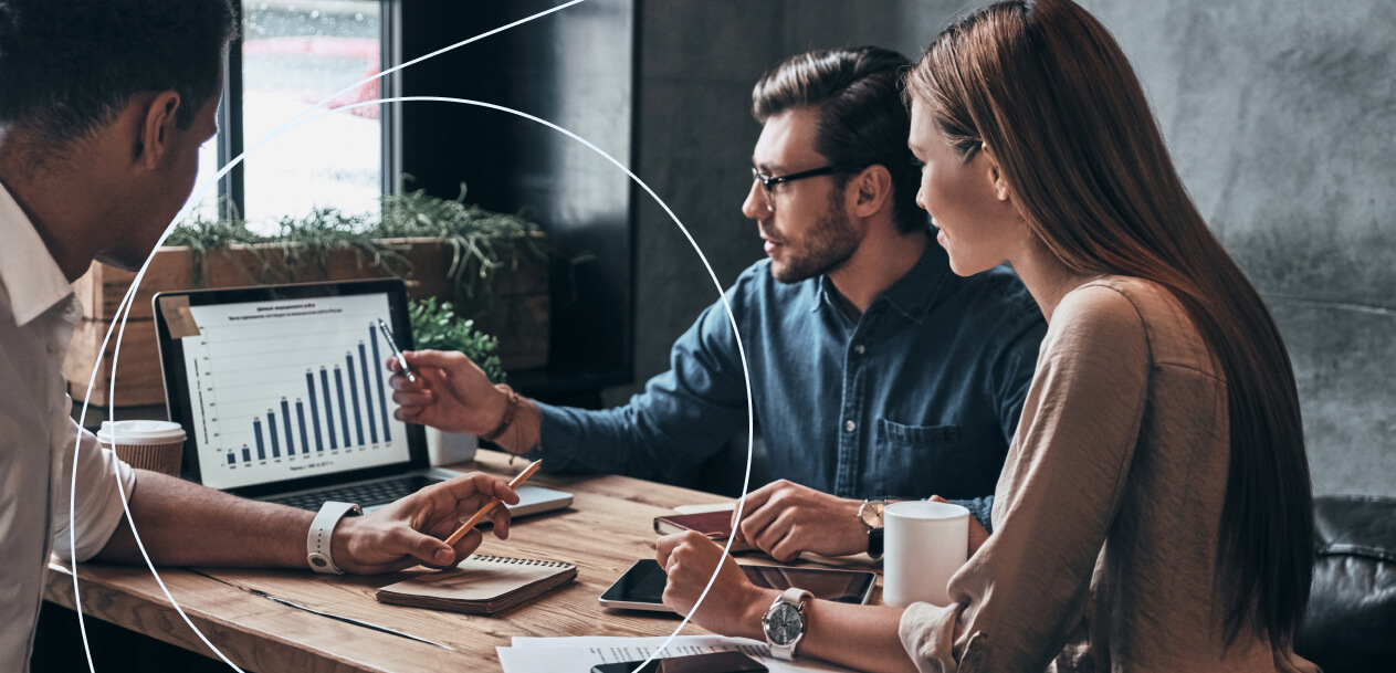 A group of three professionals, two men and one woman, discussing in an office setting, illustrating why a forex trading plan matters and how to build one.