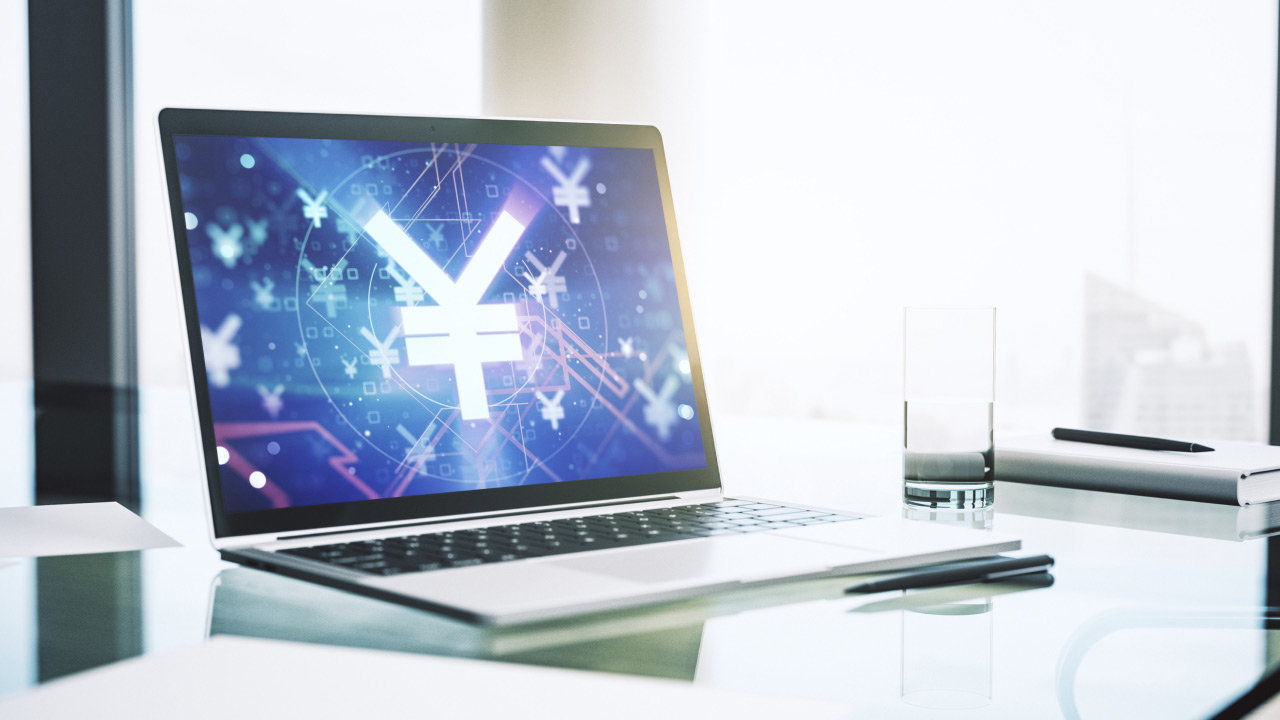 Laptop displaying a glowing Japanese yen (¥) symbol among digital financial graphics