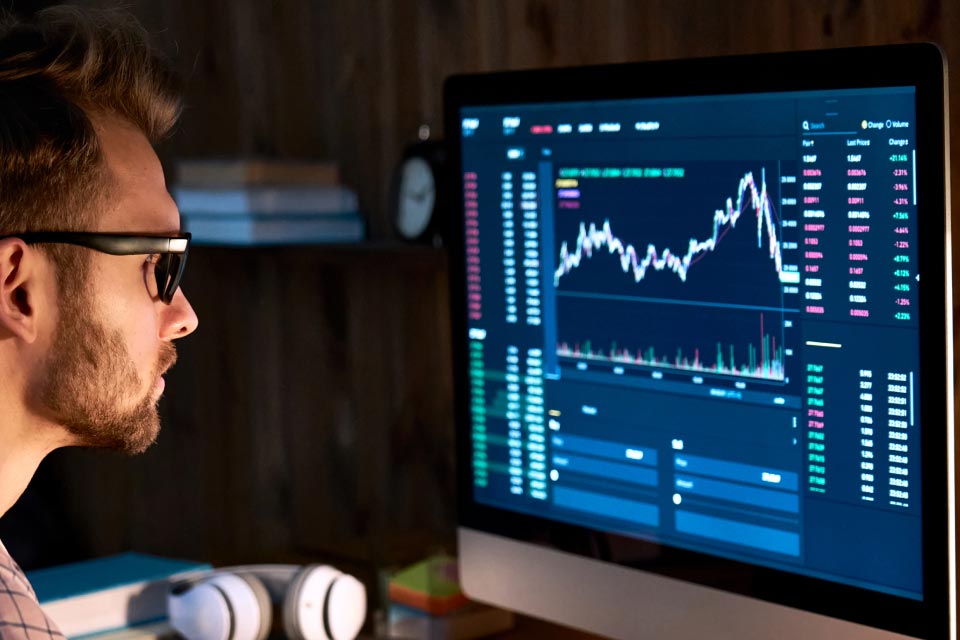 a focused analyzing a forex trading platform displayed on a desktop monitor