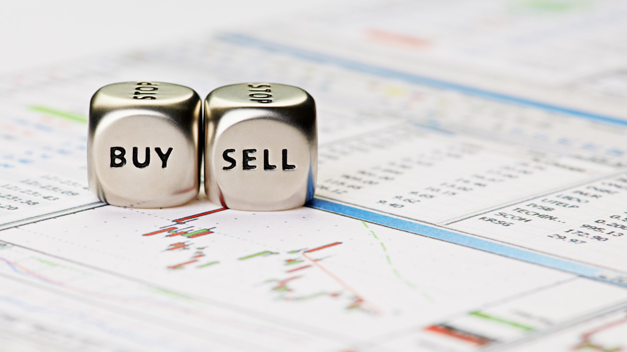 Image of two metallic dice placed on a financial chart, illustrating the concept of what competitive spreads are.