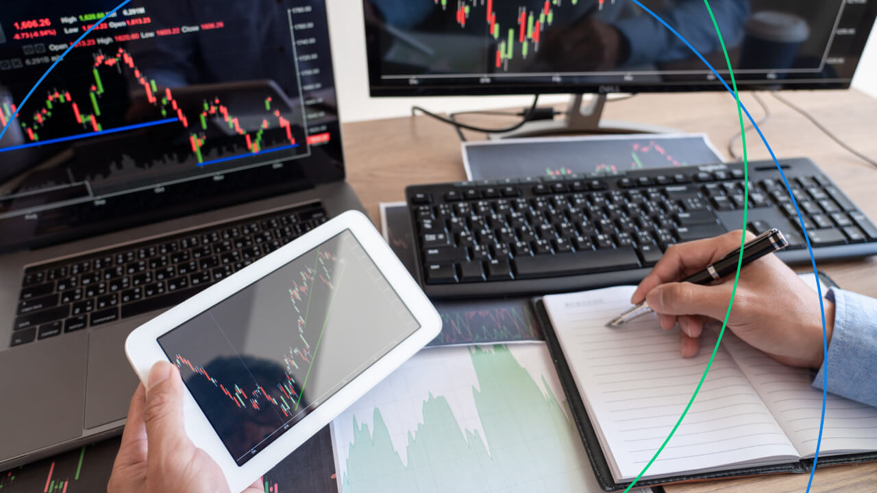 Automated Trading vs Manual Trading: A trader analyzing forex charts on multiple screens while taking notes.