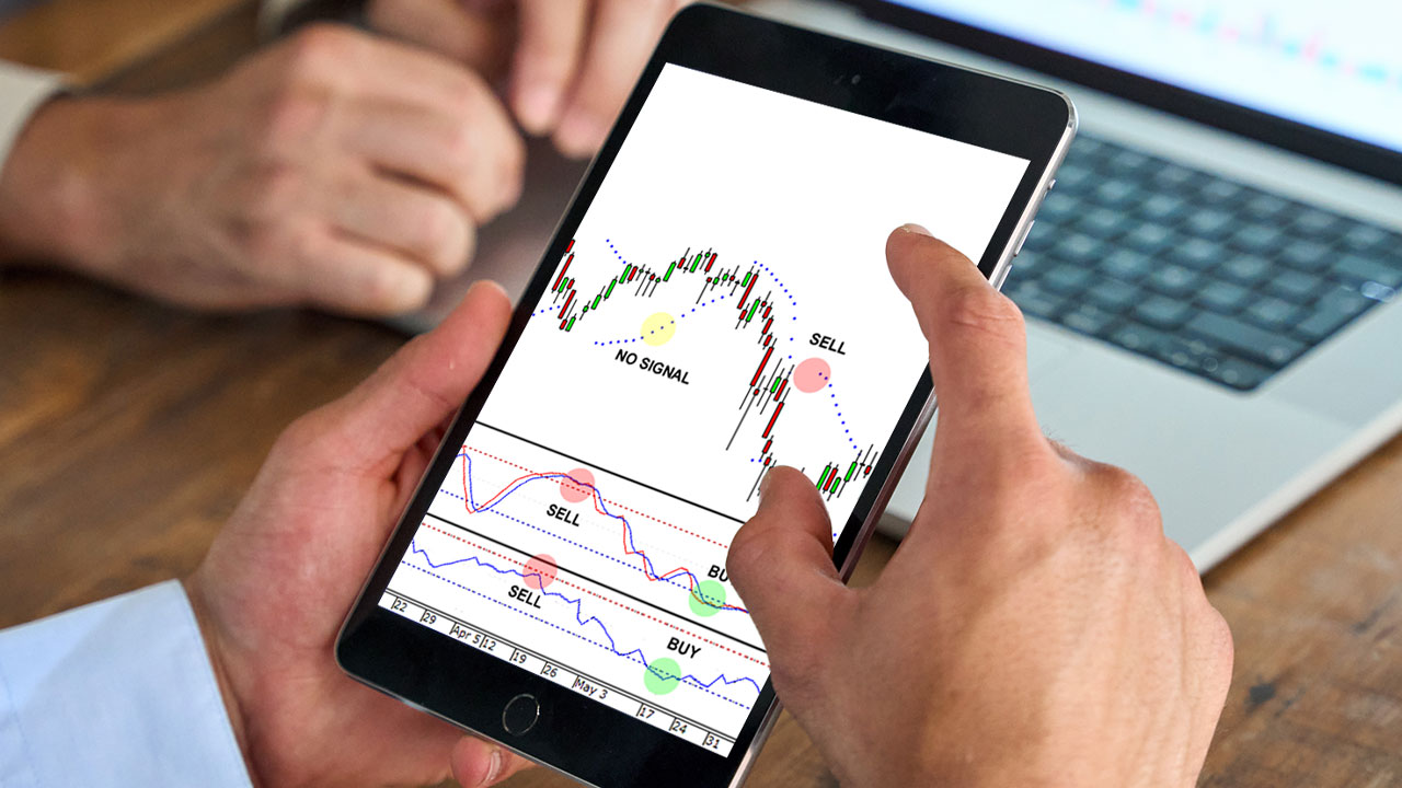 a person holding a tablet displaying a forex trading chart with technical indicators.