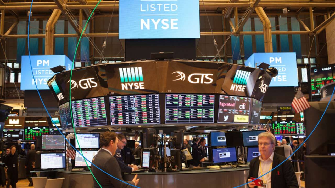 CFDs vs Stocks: Which is a Better Investment? – A bustling trading floor at the New York Stock Exchange (NYSE), showcasing digital stock tickers, financial data screens, and traders engaged in market activities.