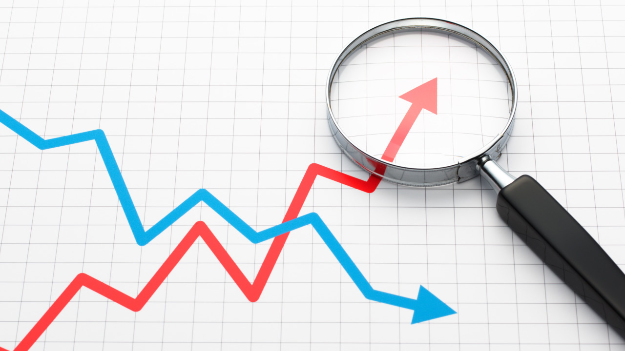 A magnifying glass focusing on a red upward trend line, illustrating five trading strategies for a highly volatile market