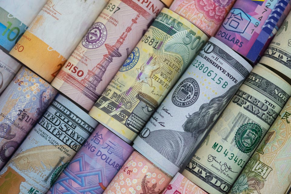 Various international currencies rolled up side by side, illustrating leverage in forex