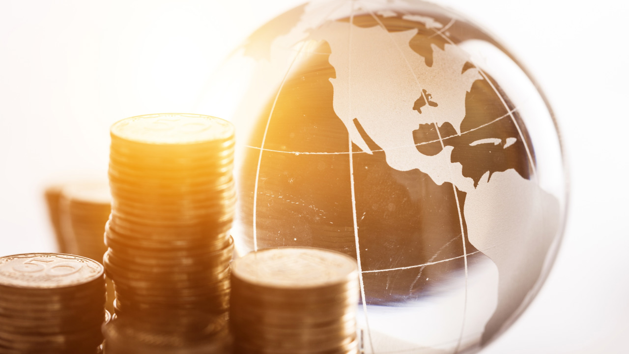 stacks of coins are placed beside a transparent globe
