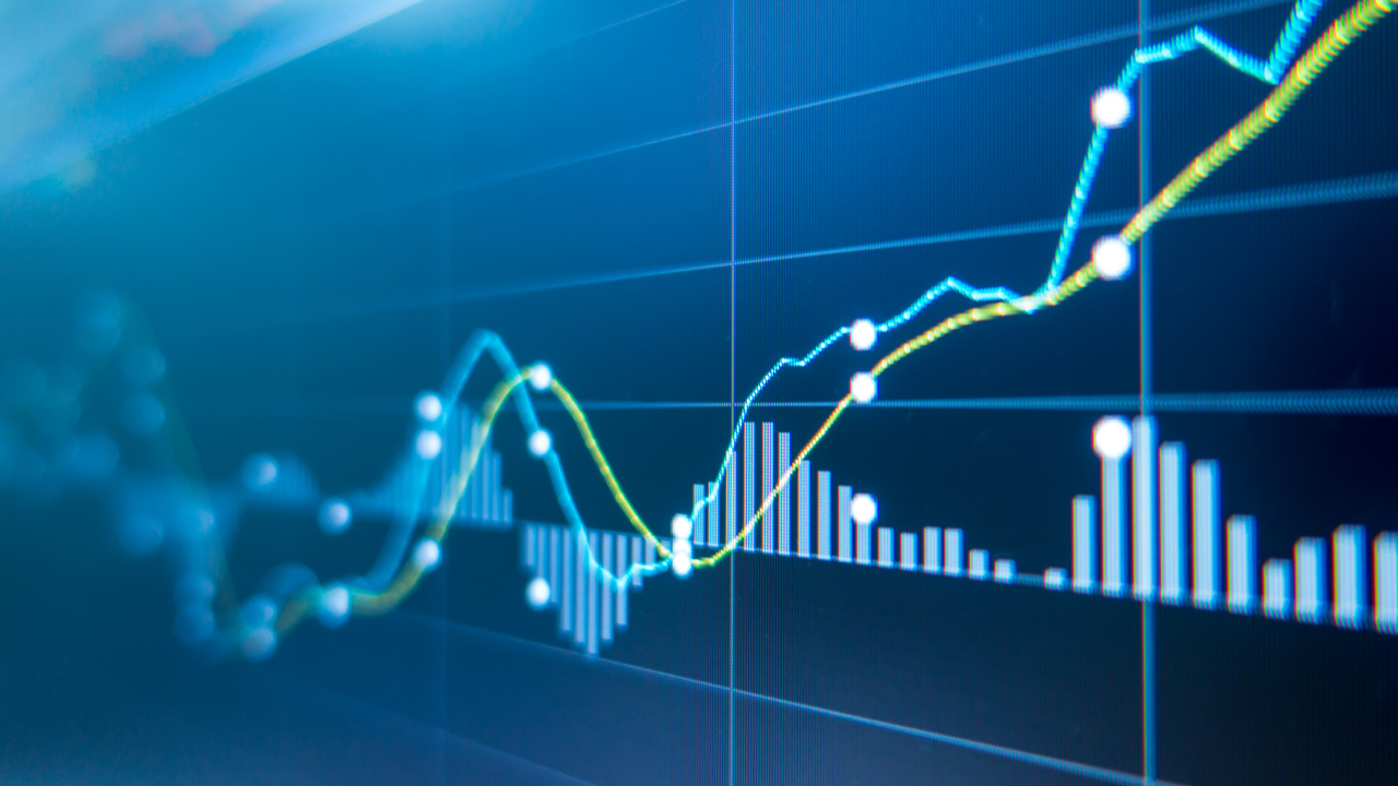 Tips on Exchange Rate When Exchanging Foreign Currency to Vietnamese Dong, illustrated by a close-up of a financial graph showing rising and falling lines with bar charts on a blue background.