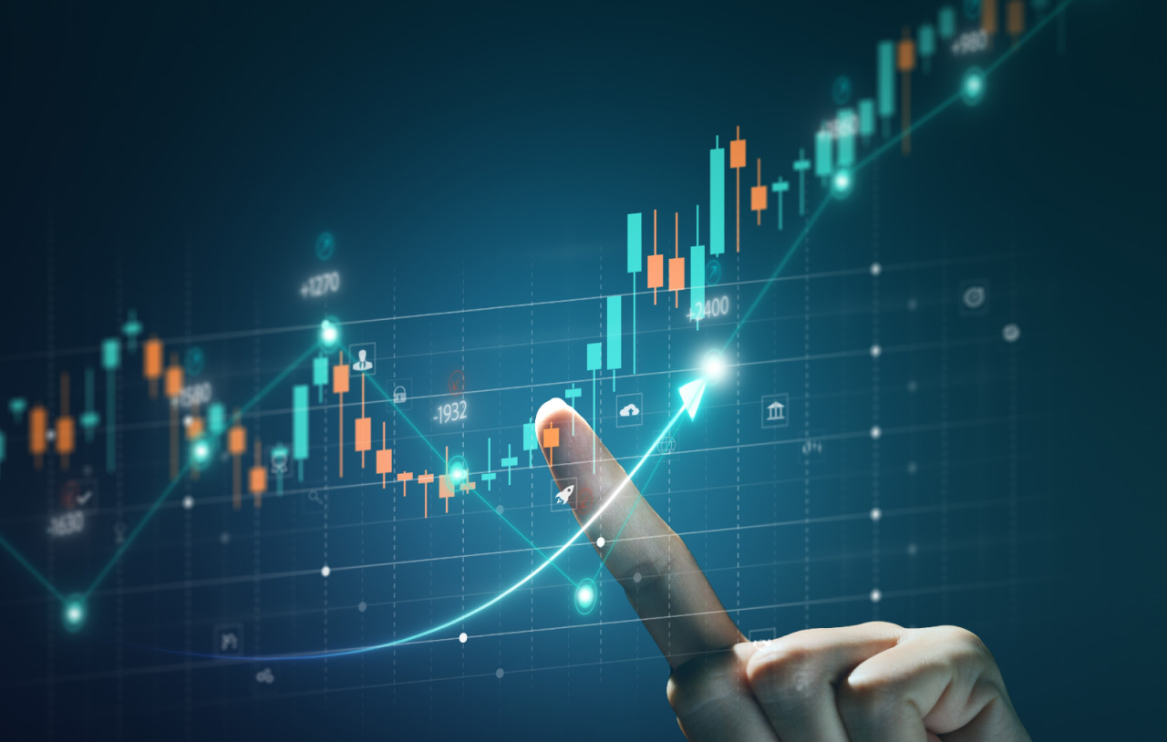 Guide to Rounding Bottom Pattern – A hand pointing at a digital candlestick chart with an upward trend, illustrating a rounding bottom pattern in trading analysis.