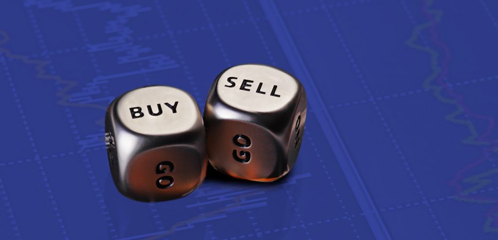 Two metallic dice on a blue financial chart background. One die shows the word 'BUY' and the other 'SELL,'
