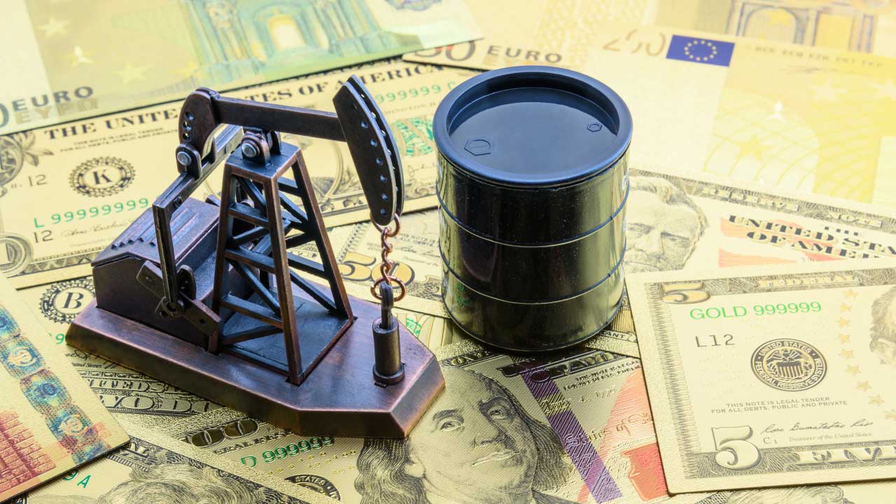Understanding the Relationship Between Oil and Currency, illustrated by a miniature oil pump jack and a black oil barrel placed on top of various global currencies.