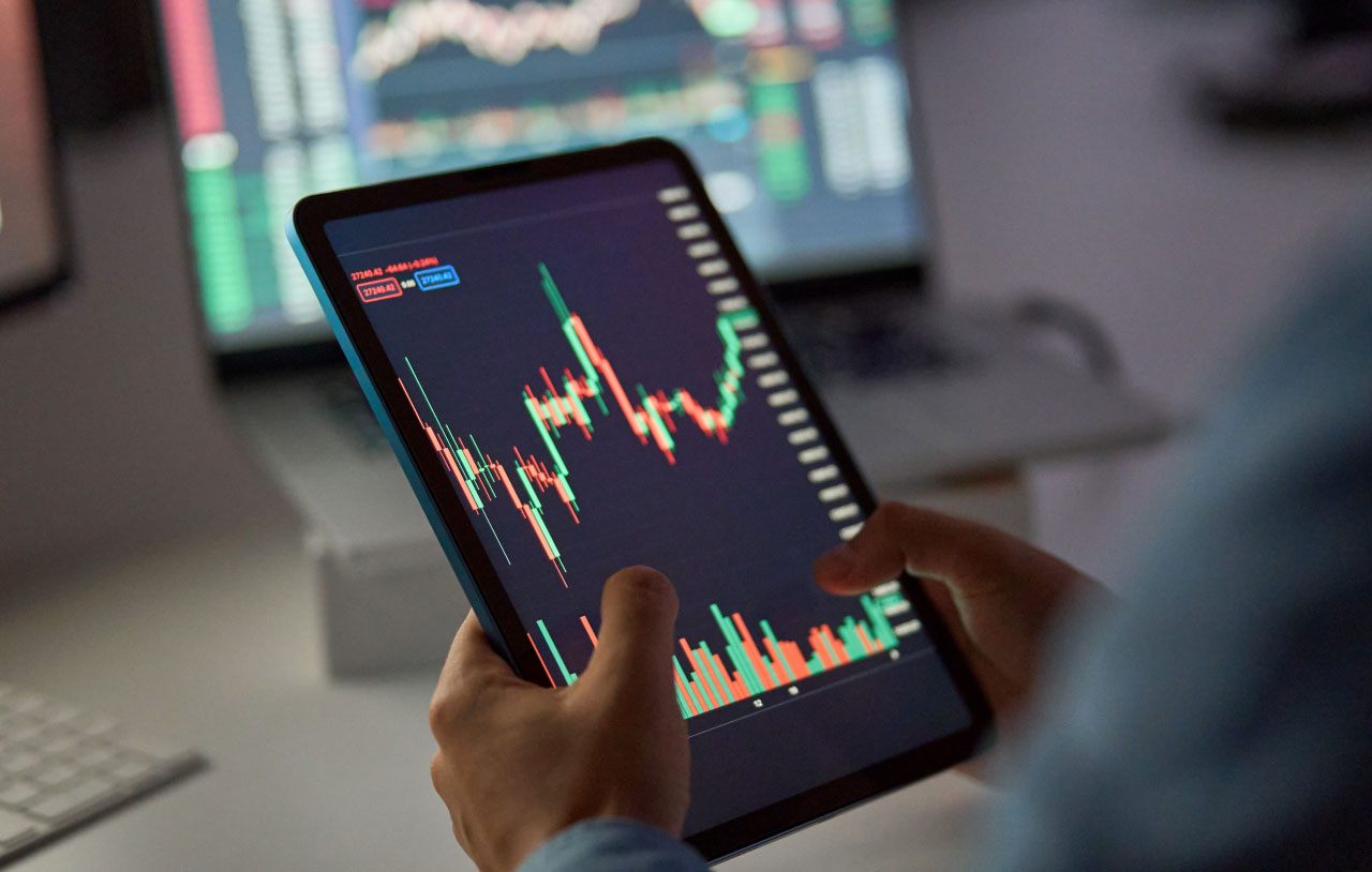 McClellan Summation Index: A Deep Dive – A trader analyzing market trends on a tablet, with financial charts displayed in the background.