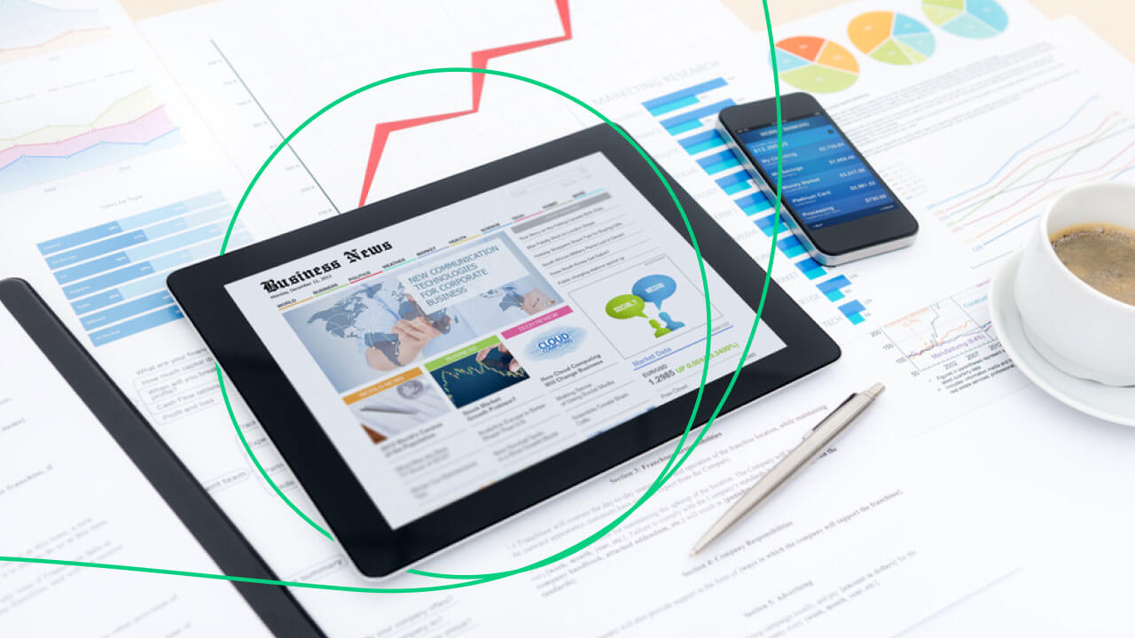 Top Economic Indicators Traders Should Watch, illustrated by a tablet displaying business news on a desk with financial reports, a smartphone, a pen, and a cup of coffee.
