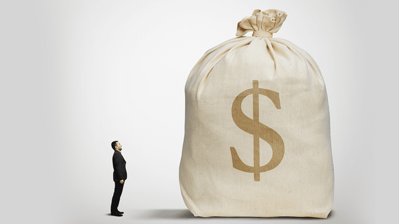 man looking at a big bag of money