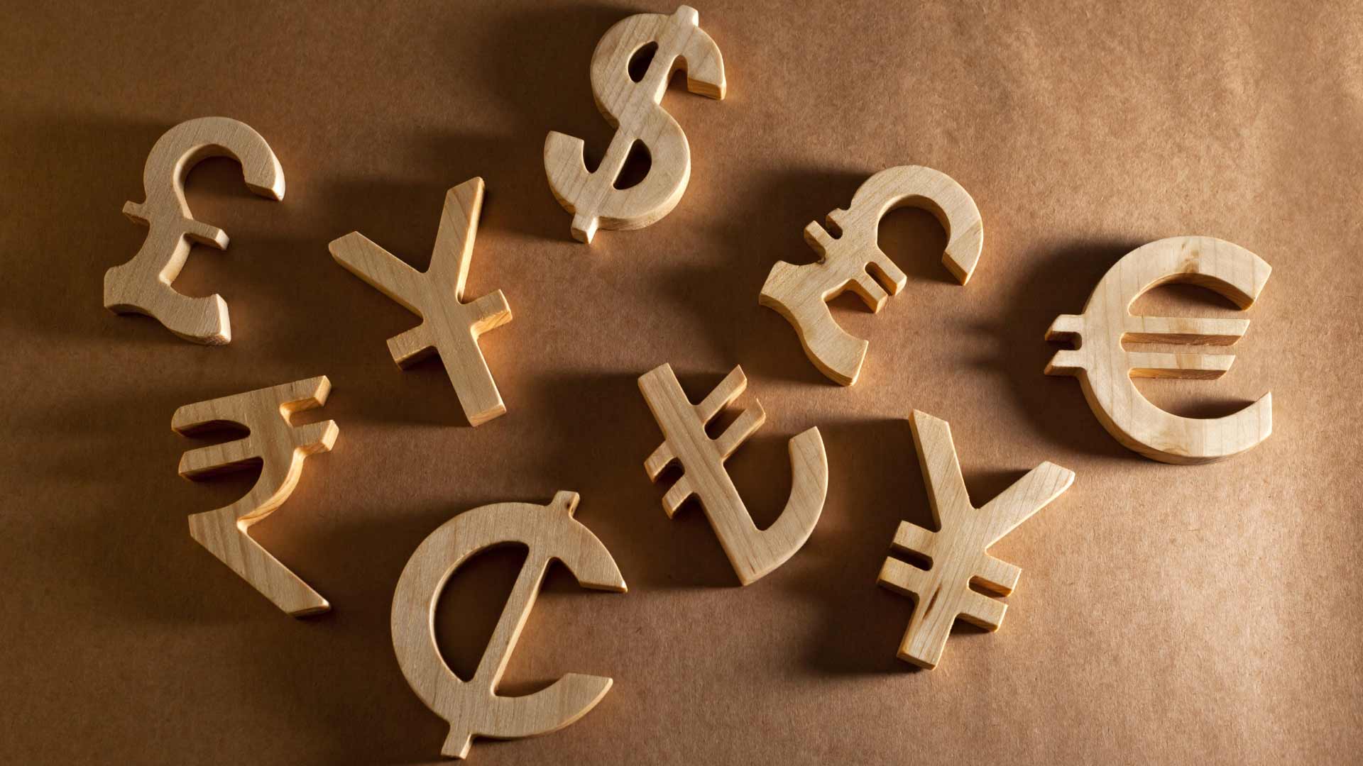 Wooden cutouts of various currency symbols