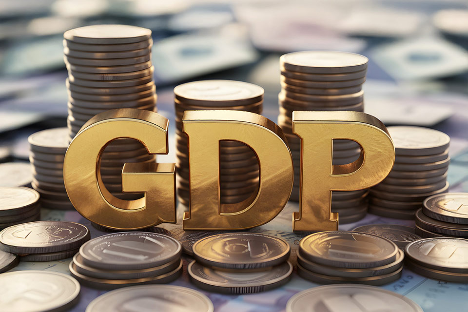 golden GDP letters surrounded by stacks of coins, 