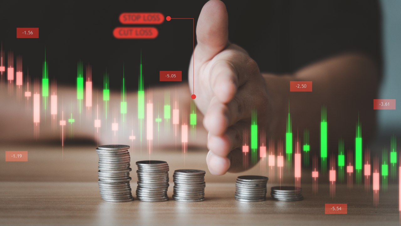 A hand stopping falling coin stacks overlaid with a financial candlestick chart, highlighting the concept of risk management. Labels for 'Stop Loss' and 'Cut Loss' emphasize differences between hedging and stop-loss strategies.