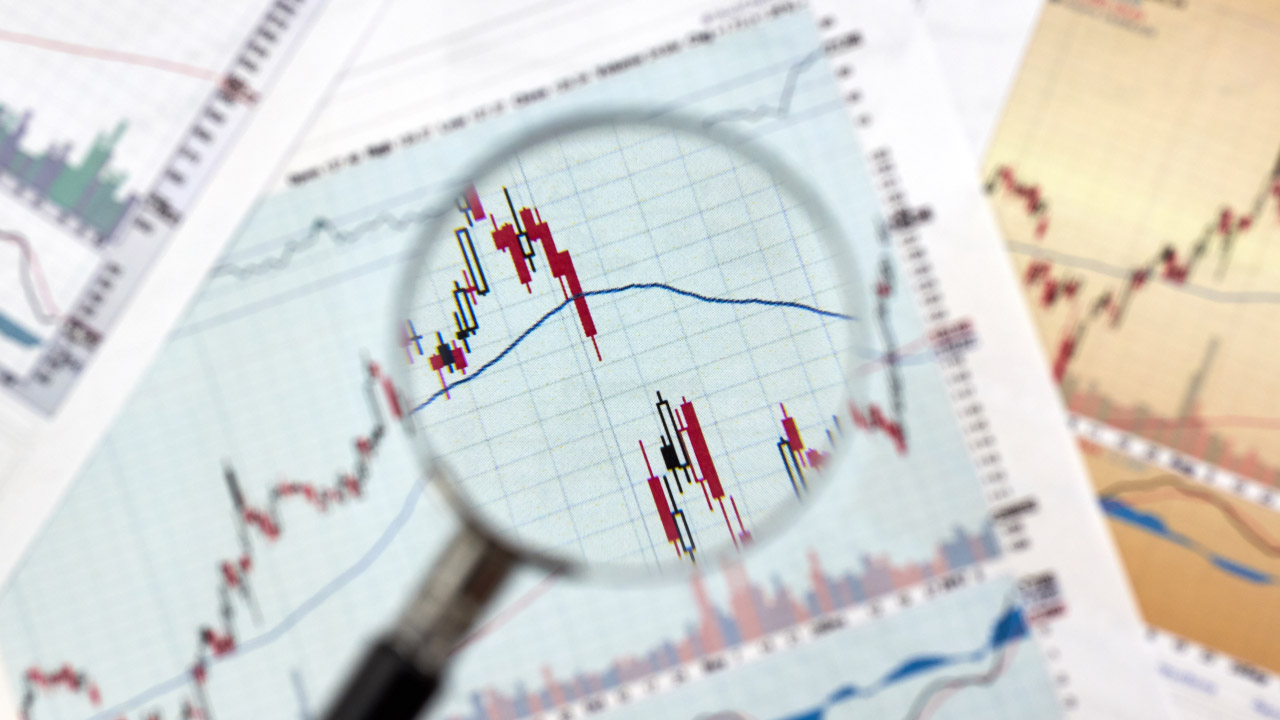 Magnifying glass focusing on a forex candlestick chart with a price gap, highlighting top gap trading strategies in financial markets.