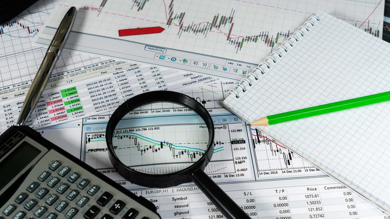A collection of financial documents, charts, and graphs on a desk, illustrating the concept of a Floating Exchange Rate.