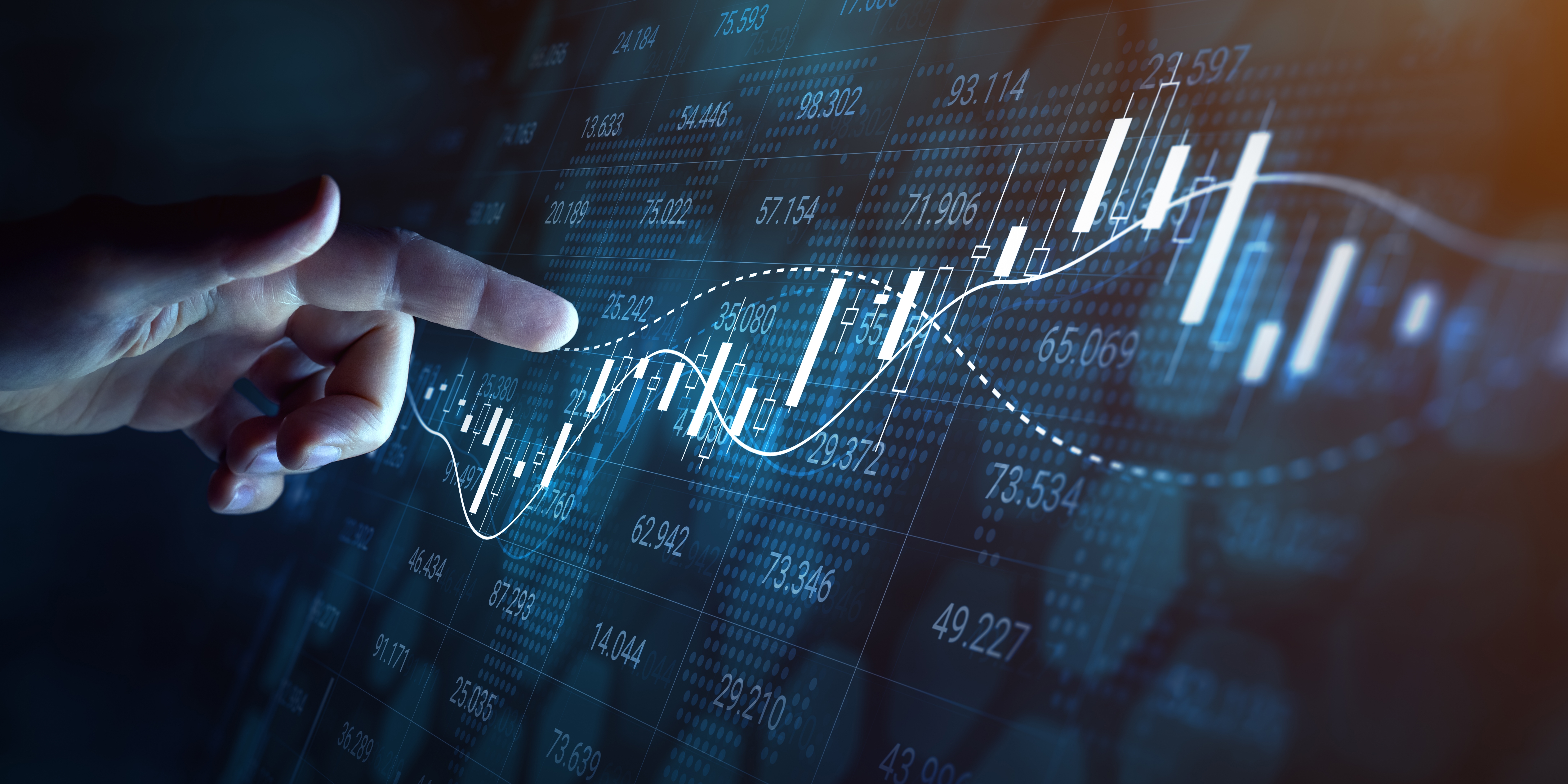 Hand pointing at a digital financial chart with candlestick patterns and trend lines, representing trend-following strategies in trading.