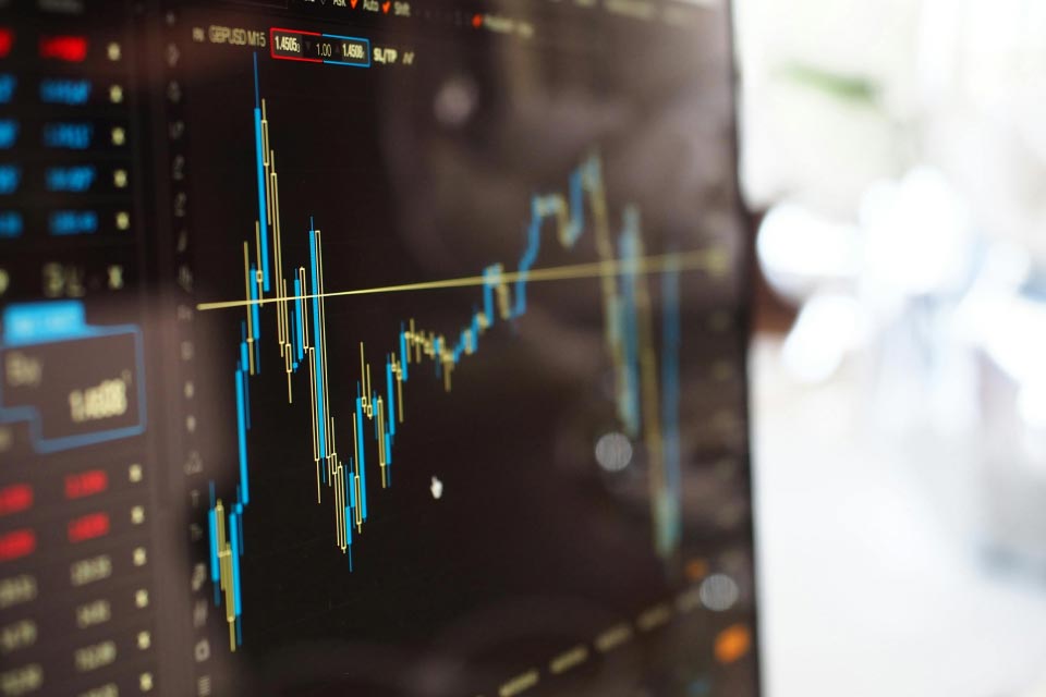 Trading monitor displaying a GBP/USD candlestick chart with oscillating price movements, illustrating how to use the Gator Oscillator for forex trading.