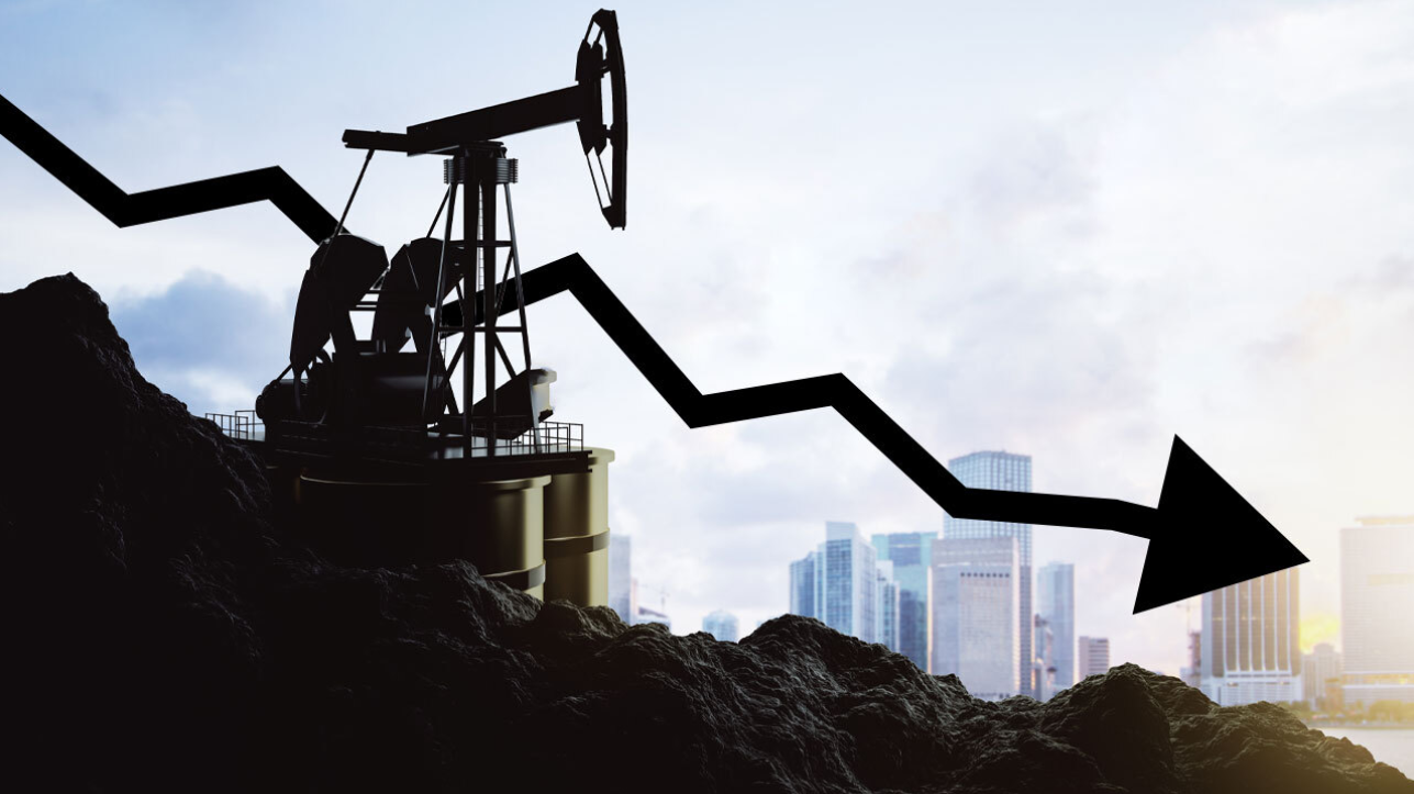 Silhouette of an oil pumpjack on a hill of crude with a bold black downward arrow indicating falling oil prices, set against a modern city skyline.