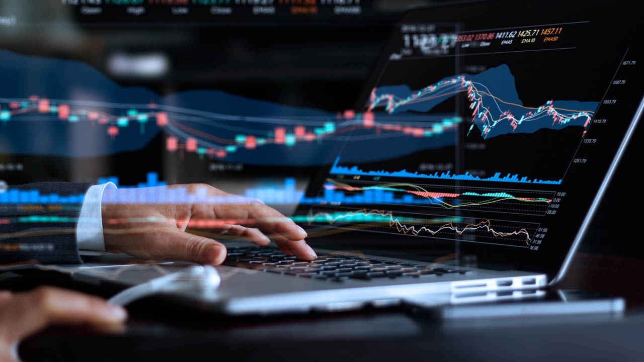 Trader analyzing stock market charts on a laptop with financial graphs overlay, illustrating how CPI affects the stock market.