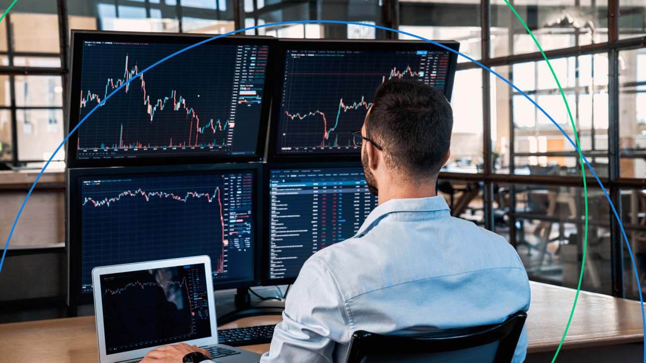 A trader analyzing multiple screens displaying financial charts and market data, representing the risks of overtrading and the importance of disciplined trading strategies.