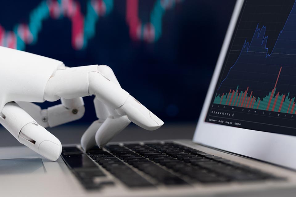 A robotic hand typing on a laptop displaying a trading chart, symbolizing automated forex trading systems and algorithmic trading, illustrating "Forex Trading Robots: How Do They Work?"